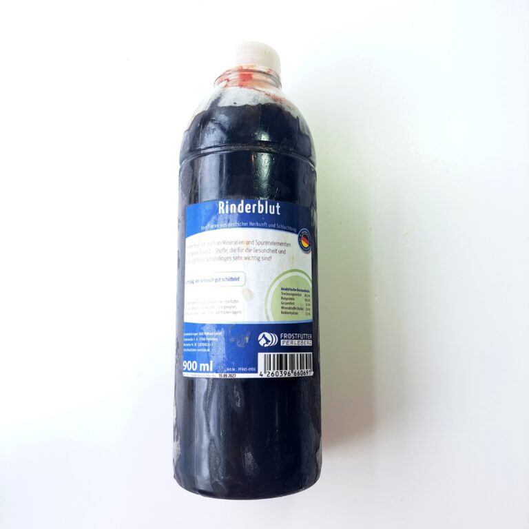 man sieht eine durchsichtige Kunststoff Flasche mit dunklem gefrorenen Blut