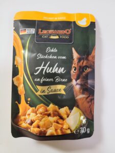 Huhn an feiner Birne. Zu sehen ist ein Kätzchen und ein Teller mit Fleischstücken