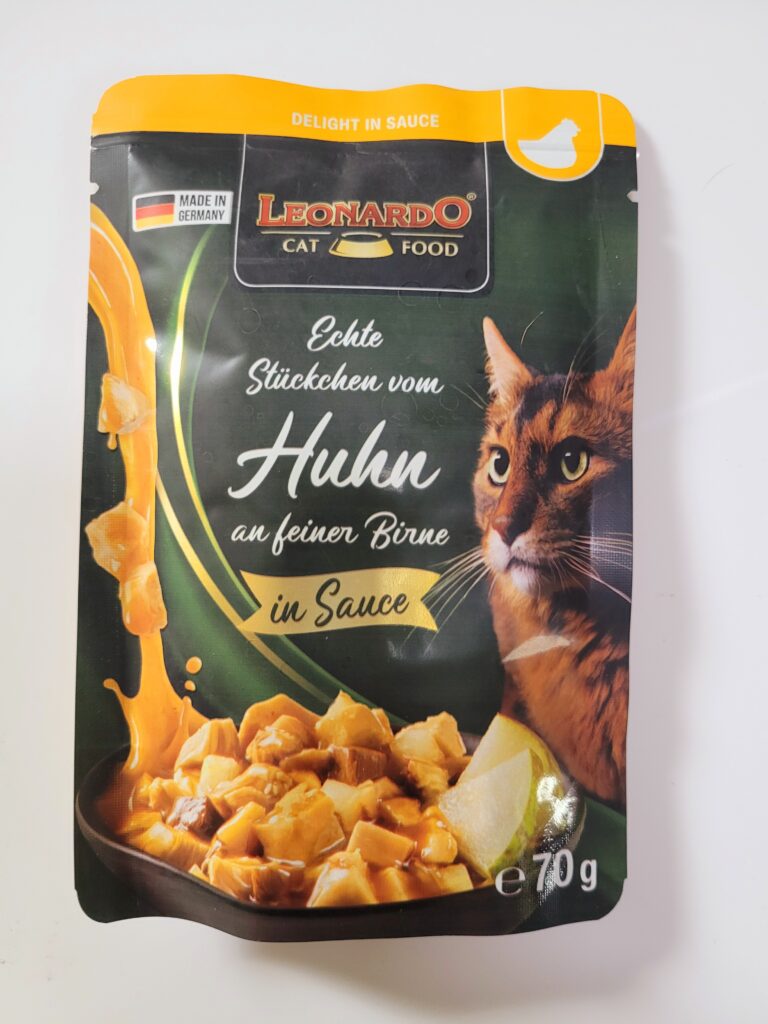 Huhn an feiner Birne. Zu sehen ist ein Kätzchen und ein Teller mit Fleischstücken